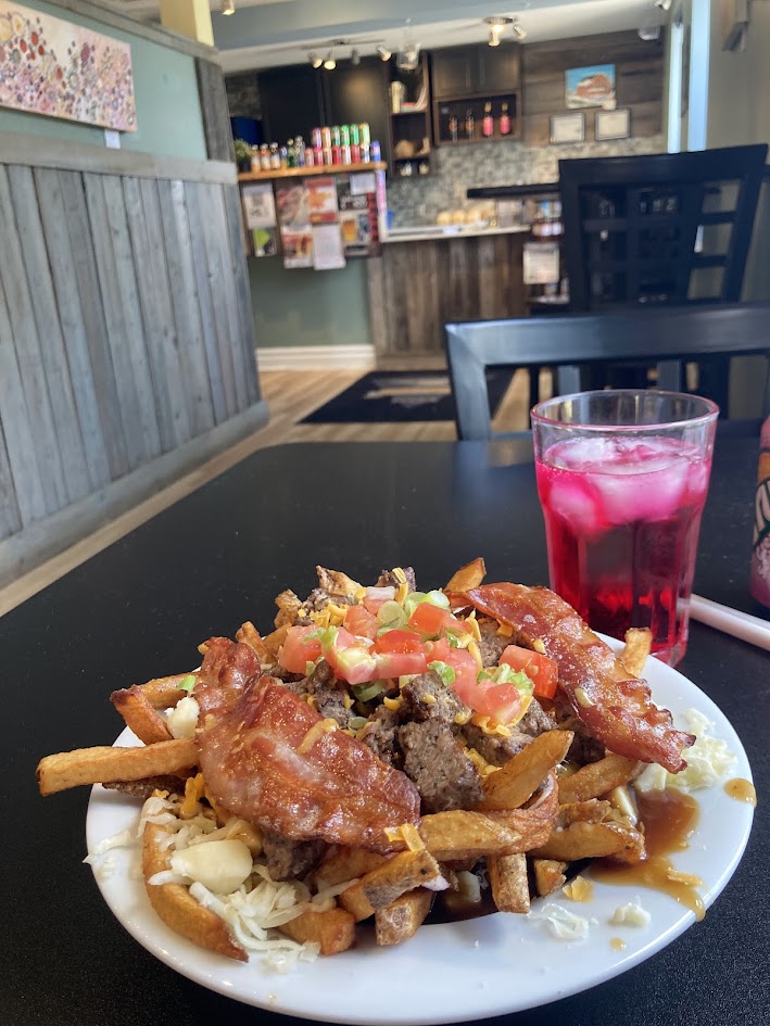 My meal at a restaurant in Merrickville - a cheeseburger poutine and a pop.